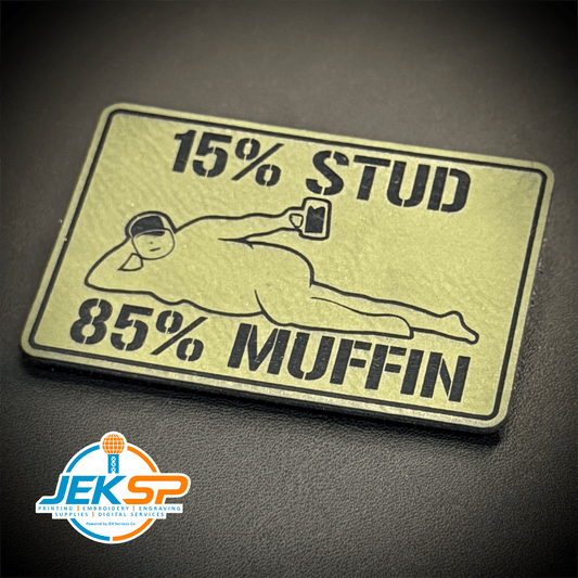Front view of 15% Stud 85% Muffin patch in tan with black lettering and muffin graphic