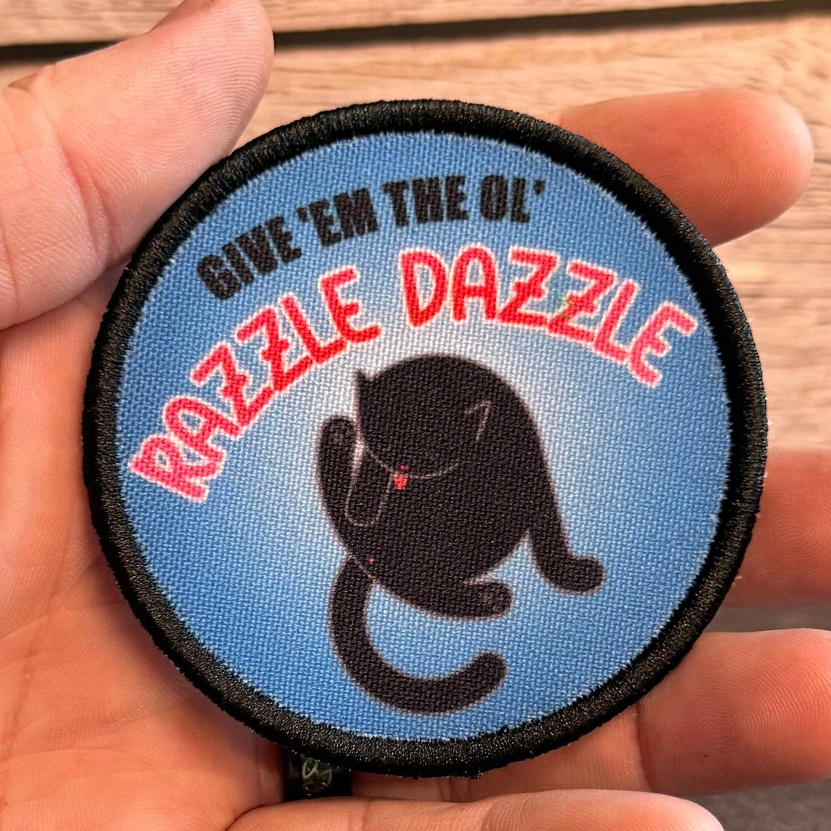 Give 'Em The Razzle Dazzle Funny Morale Patch, 3" Round | Made in USA | VELCRO® Brand Hook Backing
