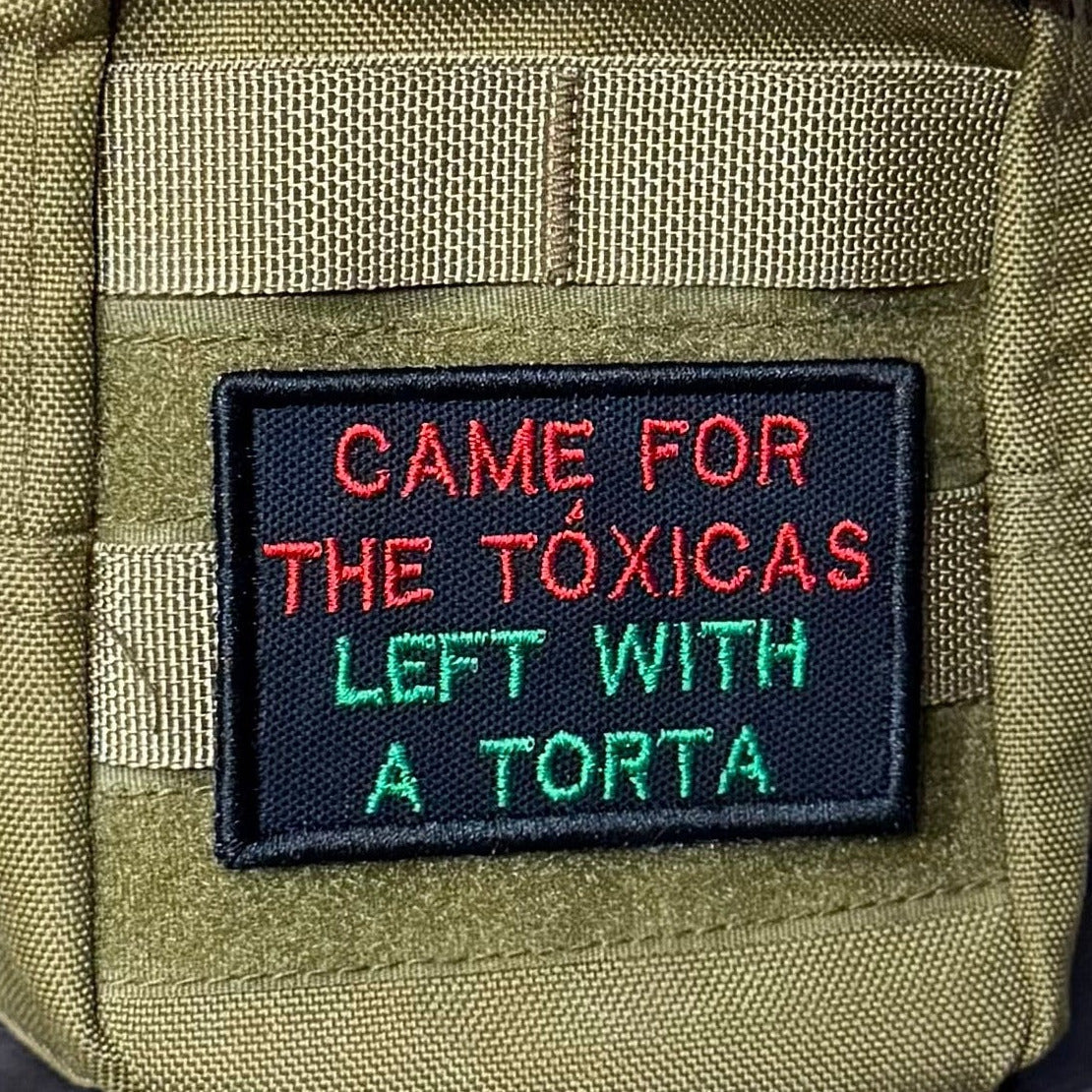 Came For The Toxicas, Left With A Torta patch in black with red and green lettering, mounted on an olive backpack