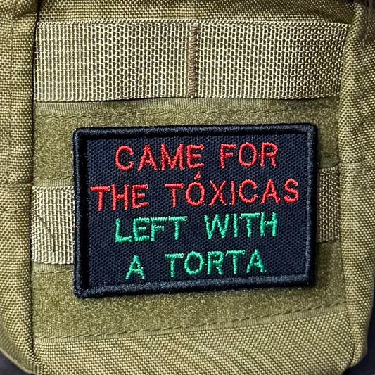 Came For The Toxicas, Left With A Torta patch in black with red and green lettering, mounted on an olive backpack