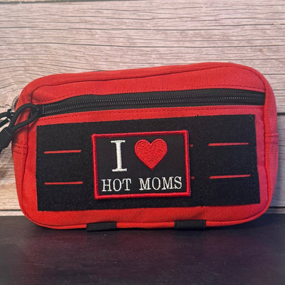 I Love Hot Moms MILFS patch in black with a red heart and border and white lettering, mounted on a red utility pouch