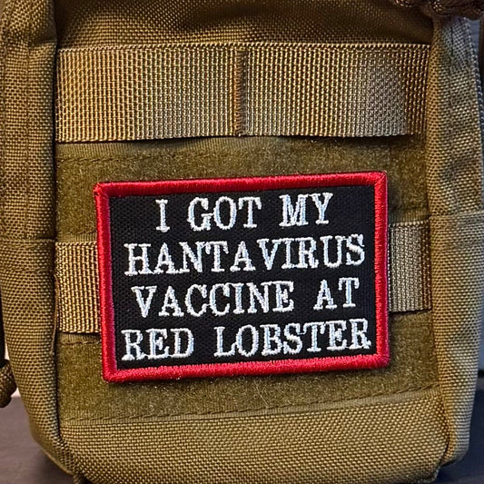 I Got My Hantavirus Vaccine At Red Lobster patch in black with white lettering and a red border, mounted on an olive backpack