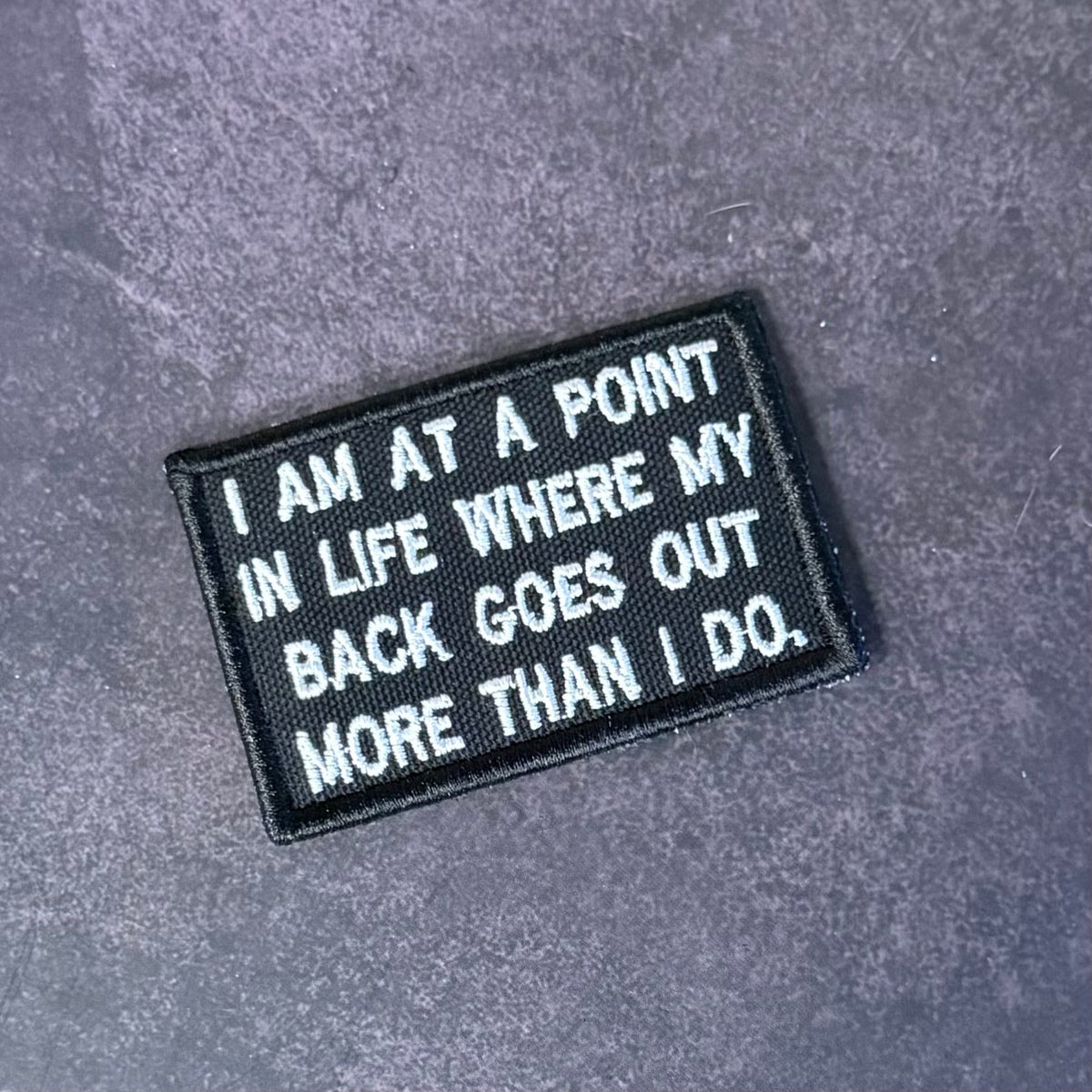 Front view of My Back Goes Out More Than I Do patch in black with white lettering