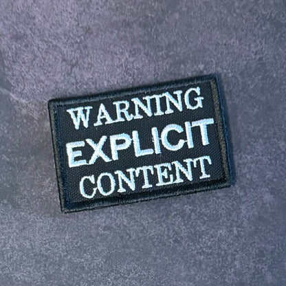Front view of Explicit Content Warning patch in black with white lettering
