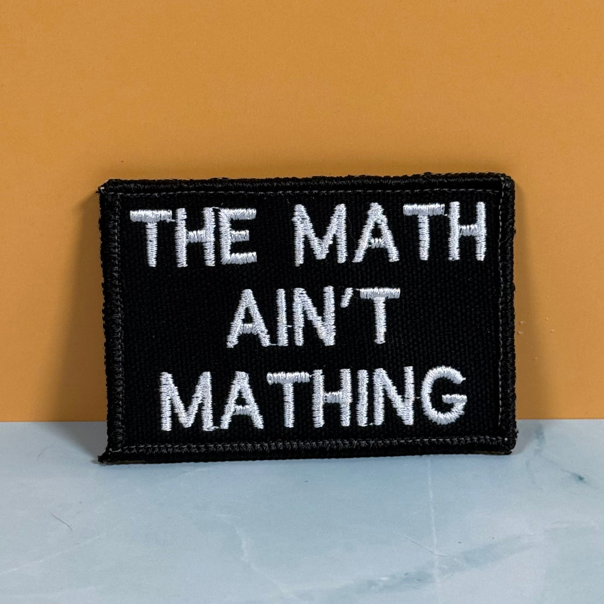 Front view of The Math Ain't Mathing patch in black with white lettering