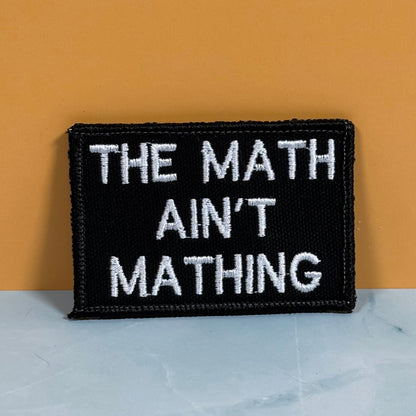 Front view of The Math Ain't Mathing patch in black with white lettering