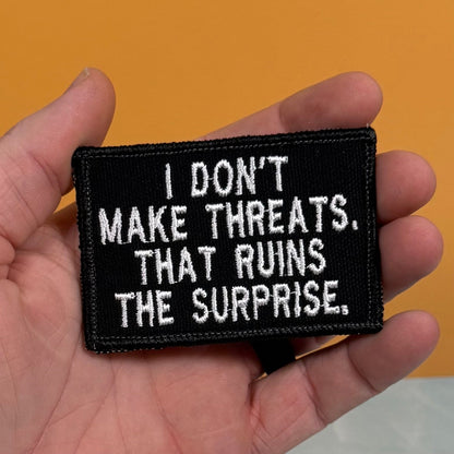 I Don't Make Threats, That Ruins The Surprise Funny Morale Patch, 2x3" | Made in USA | VELCRO® Brand Hook Backing
