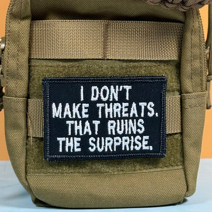 I Don't Make Threats, That Ruins The Surprise Funny Morale Patch, 2x3" | Made in USA | VELCRO® Brand Hook Backing