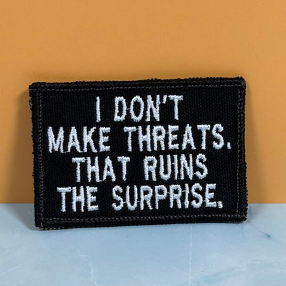 I Don't Make Threats, That Ruins The Surprise Funny Morale Patch, 2x3" | Made in USA | VELCRO® Brand Hook Backing