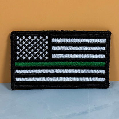 Front view of Thin Green Line Tactical American Flag patch in black and white American flag with one green stripe