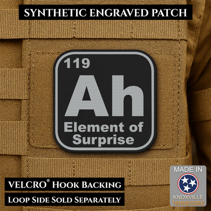 Front design and hook backing of Ah, The Element of Surprise patch in black / silver