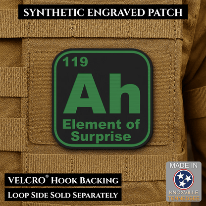 Front design and hook backing of Ah, The Element of Surprise patch in black / green