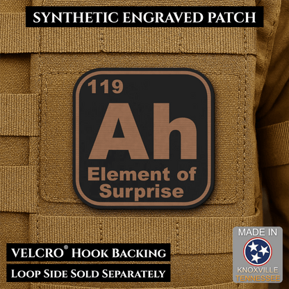 Front design and hook backing of Ah, The Element of Surprise patch in black / copper