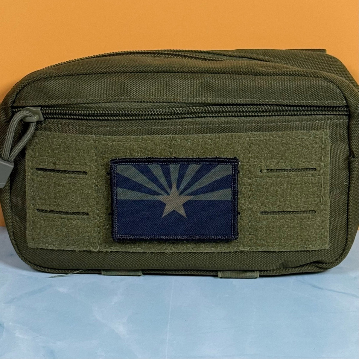 Arizona State Flag patch in subdued tan and dark blue Arizona flag with a star and radiating rays, mounted on an olive utility pouch