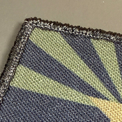 Arizona State Flag patch in subdued tan and dark blue Arizona flag with a star and radiating rays, close-up of embroidery