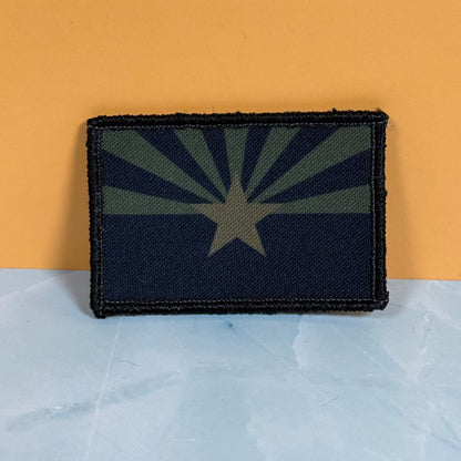 Front view of Arizona State Flag patch in subdued tan and dark blue Arizona flag with a star and radiating rays