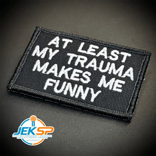 Front view of At Least My Trauma Makes Me Funny patch in black with white lettering