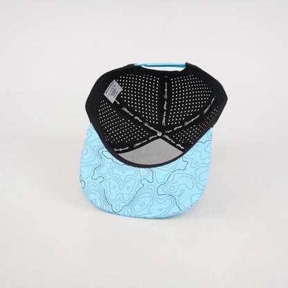 Interior and underside of a light blue topographic snapback hat blank, showing the black perforated back panels, adjustable closure, and patterned bill.