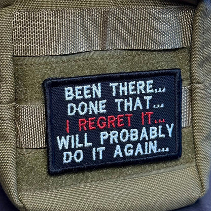 Been There, Done That, I Regret It, Will Probably Do It Again patch in black with white and red lettering, mounted on an olive backpack