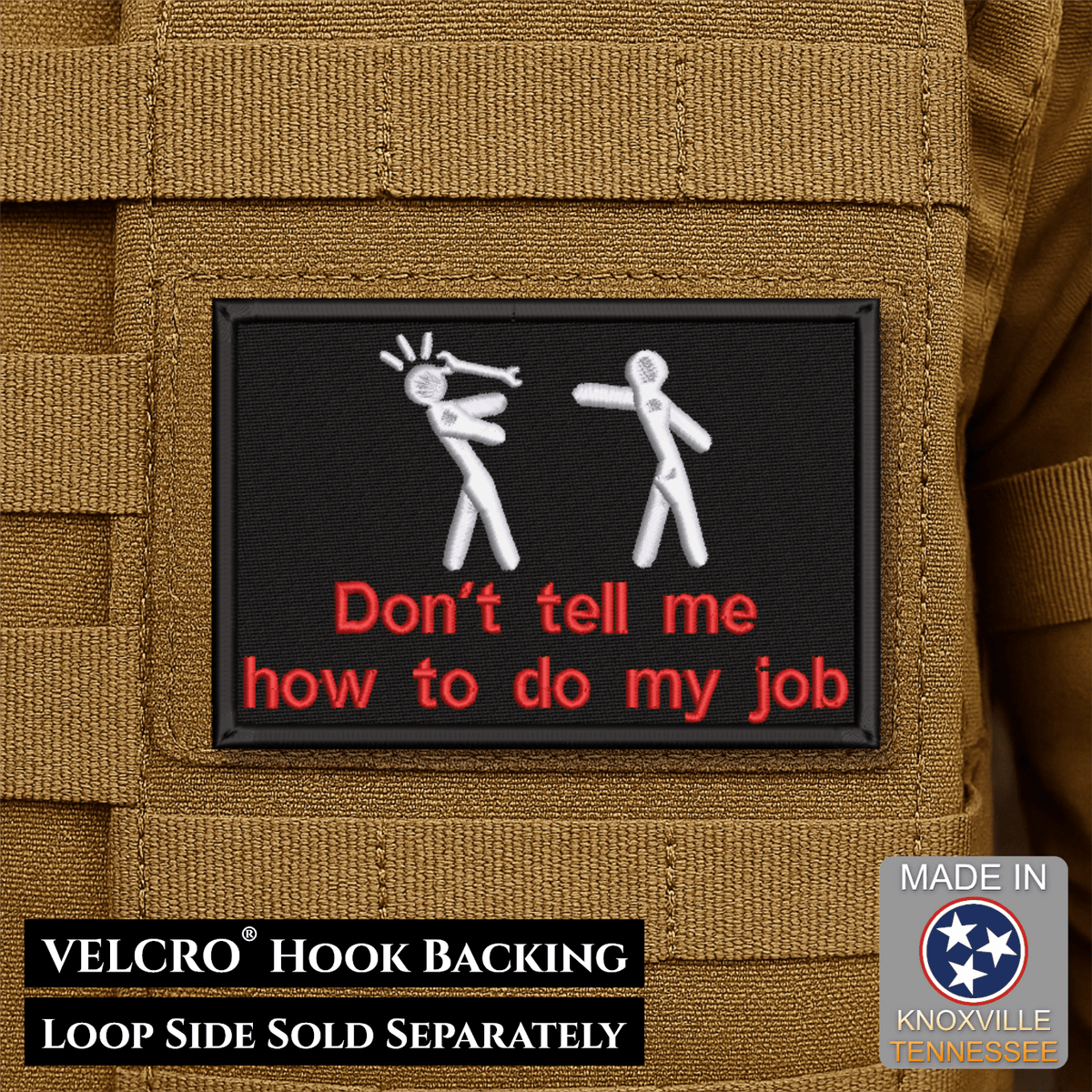 Front design and hook backing of Don't Tell Me How To Do My Job patch in black with two white figures and red lettering