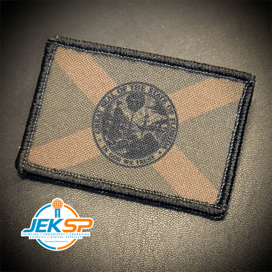 Front view of Florida State Flag patch in subdued tan and dark blue Florida flag with diagonal cross and state seal