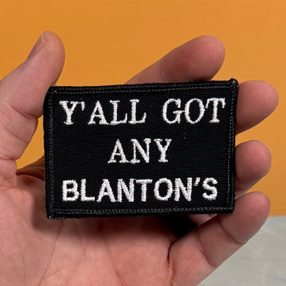 Got Any Blanton's patch in black with white lettering, held in a hand