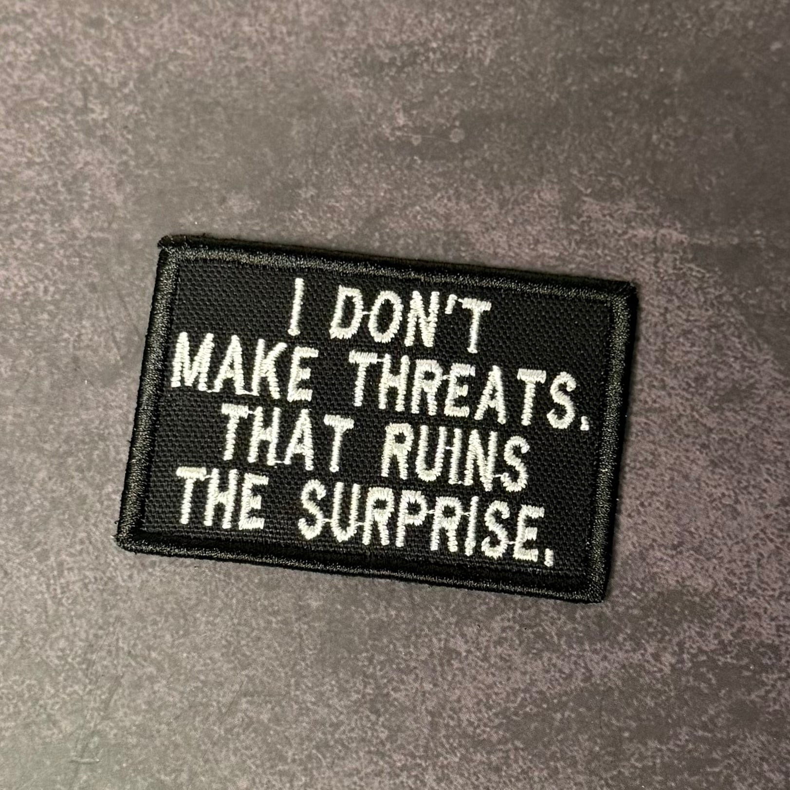 I Don't Make Threats, That Ruins The Surprise Funny Morale Patch, 2x3" | Made in USA | VELCRO® Brand Hook Backing - LoneStar Adhesive