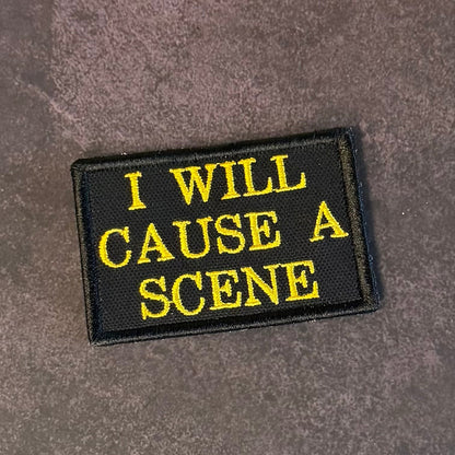 Front view of I Will Cause A Scene patch in black with yellow lettering