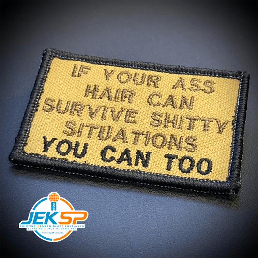 Front view of If Your Ass Hair Can Survive patch in tan with dark lettering