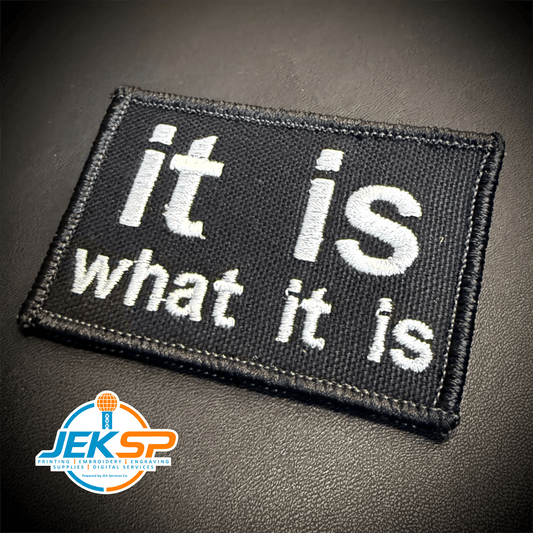 Front view of It Is What It Is patch in black with white lowercase lettering