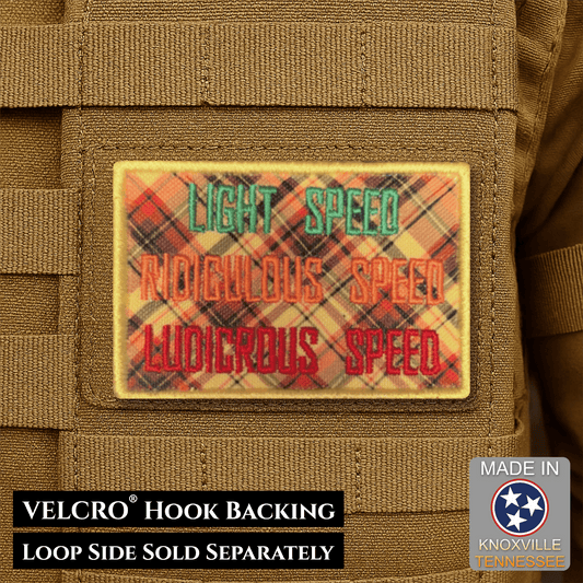 Front design and hook backing of Ludicrous Speed, They've Gone Plaid patch in multicolored plaid with green and red lettering