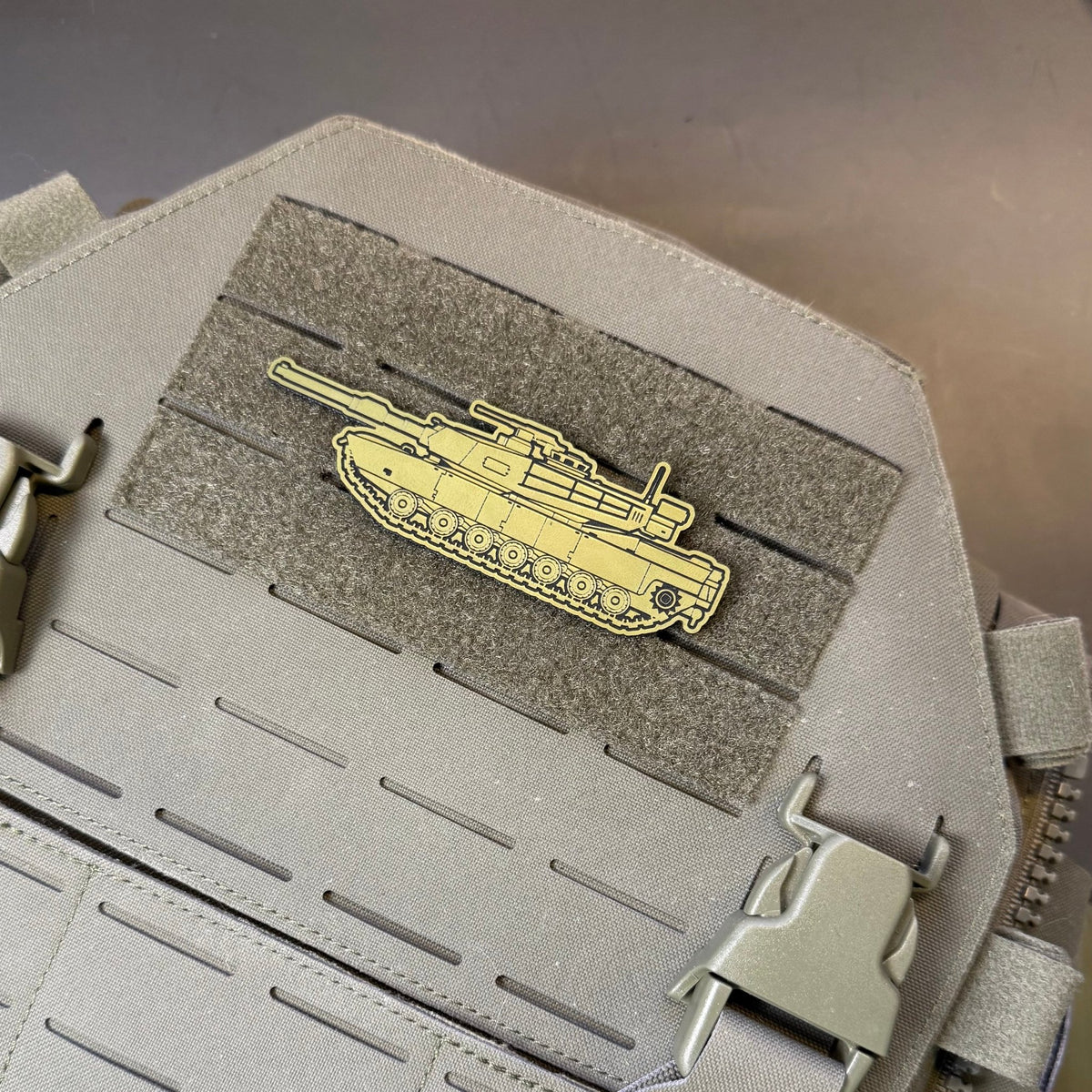 M1 Abrams Main Battle Tank patch in tan tank-shaped design with dark outlines, mounted on a tan plate carrier
