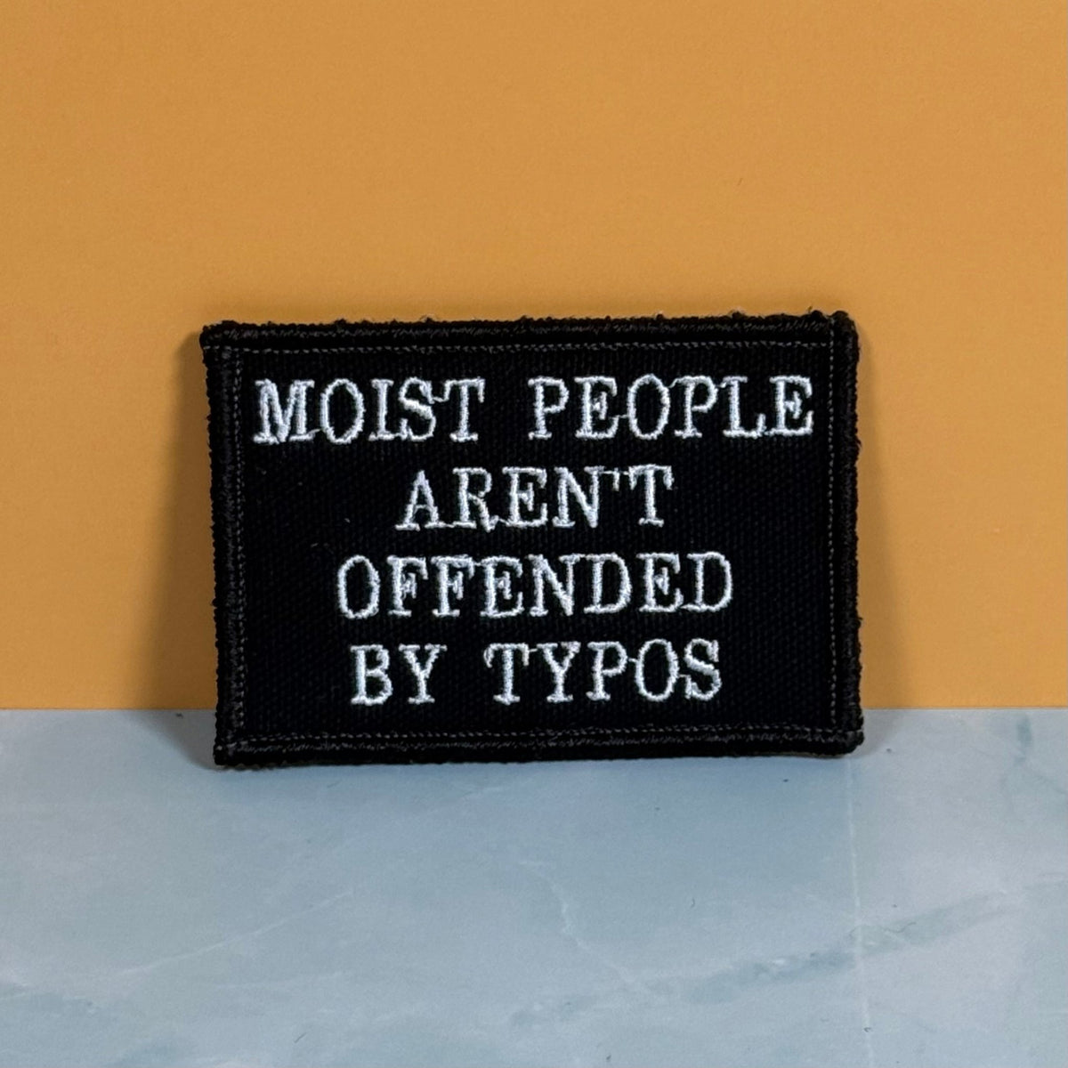 Moist People Aren’t Offended by Typos Funny Morale Patch, 2x3" | Made in USA | VELCRO® Brand Hook Backing - LoneStar Adhesive