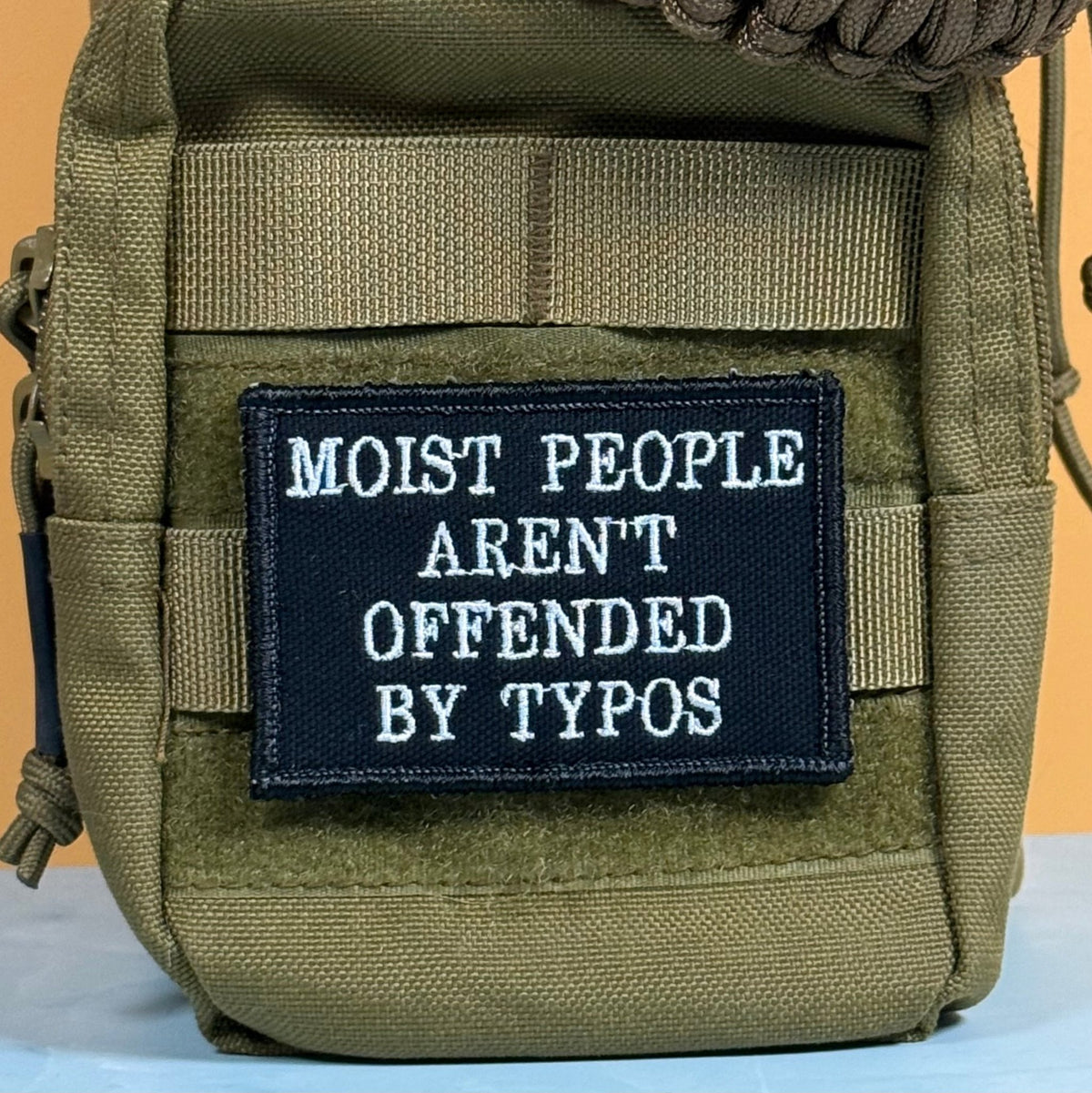 Moist People Aren’t Offended by Typos Funny Morale Patch, 2x3" | Made in USA | VELCRO® Brand Hook Backing - LoneStar Adhesive