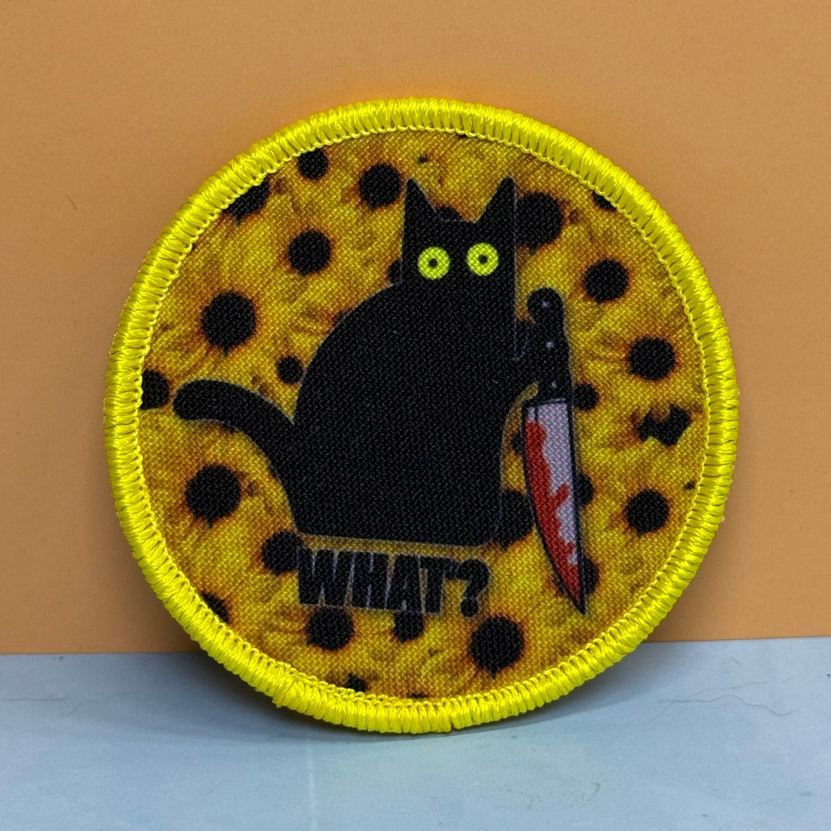 Front view of Murder Cat & Sunflowers patch in yellow with a black cat, sunflowers and a red knife