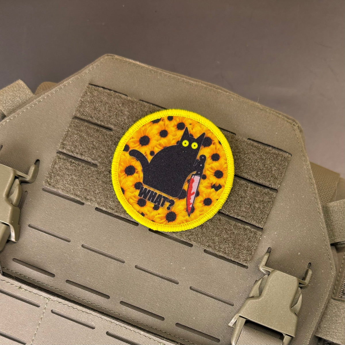 Murder Cat & Sunflowers patch in yellow with a black cat, sunflowers and a red knife, mounted on a tan plate carrier