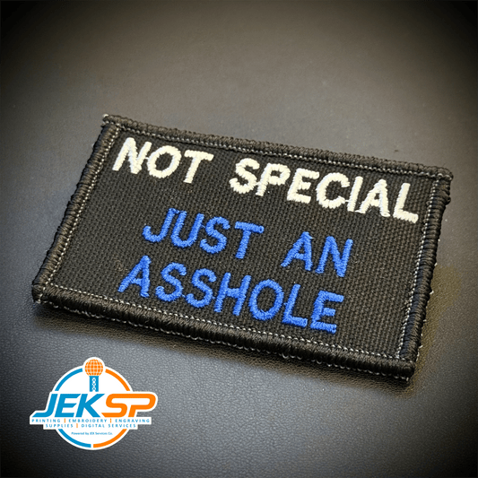 Front view of Not Special, Just An Asshole patch in black with white and blue lettering
