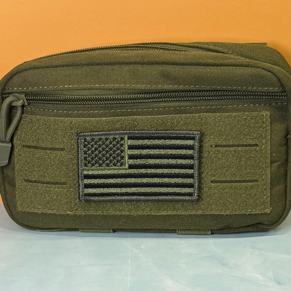 Olive OD Green Tactical American Flag patch in olive green and black stars and stripes, mounted on an olive utility pouch