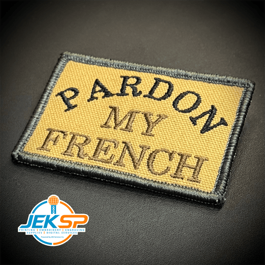 Front view of Pardon My French patch in tan with black lettering and border