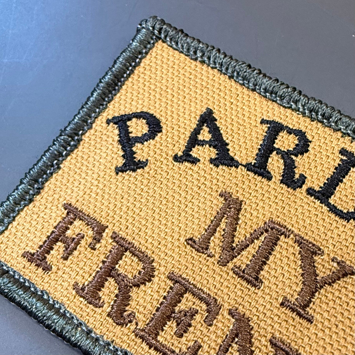 Pardon My French patch in tan with black lettering and border, close-up of embroidery