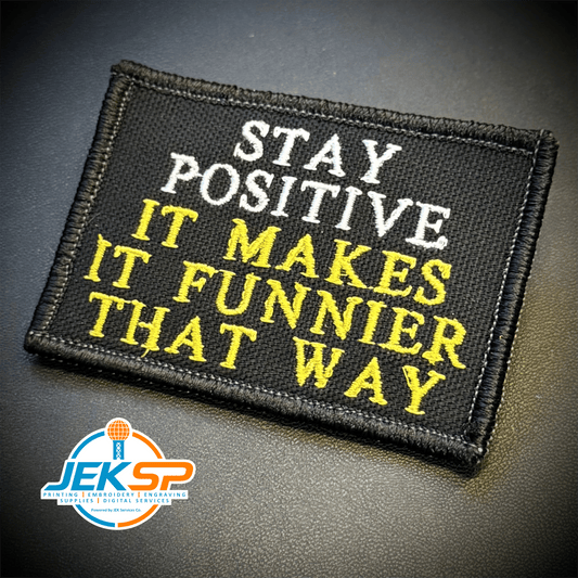 Front view of Stay Positive patch in black with white and yellow lettering