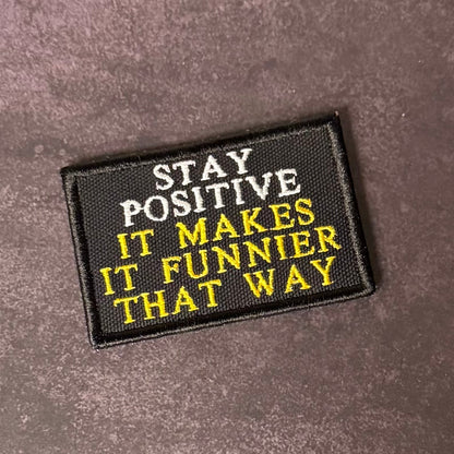 Front view of Stay Positive patch in black with white and yellow lettering