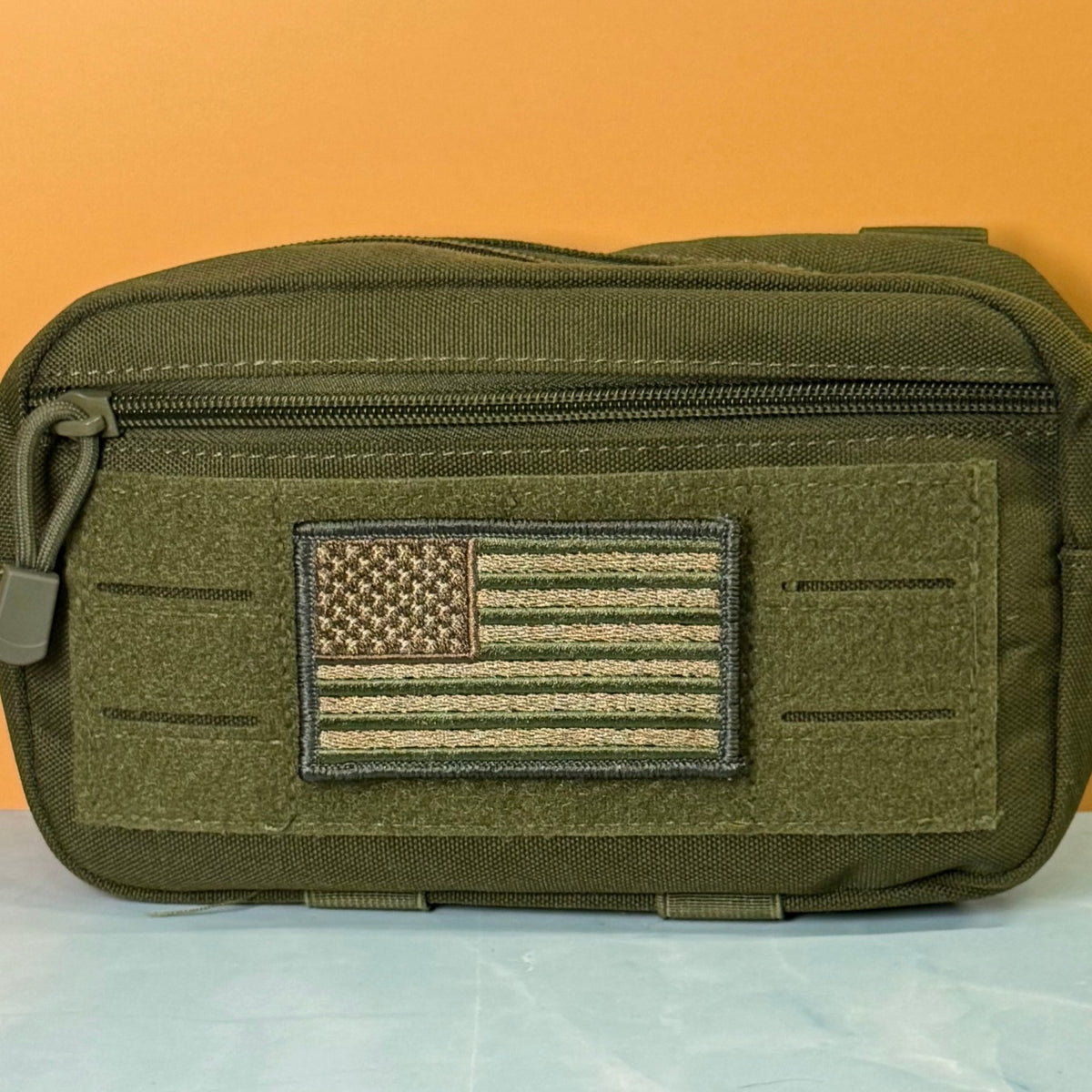 Subdued FDE Tactical American Flag patch in subdued tan and green American flag, mounted on an olive utility pouch
