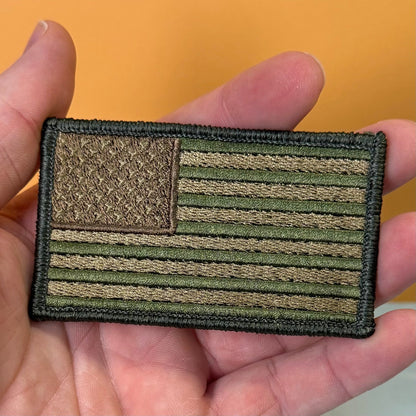 Subdued FDE Tactical American Flag patch in subdued tan and green American flag, held in a hand