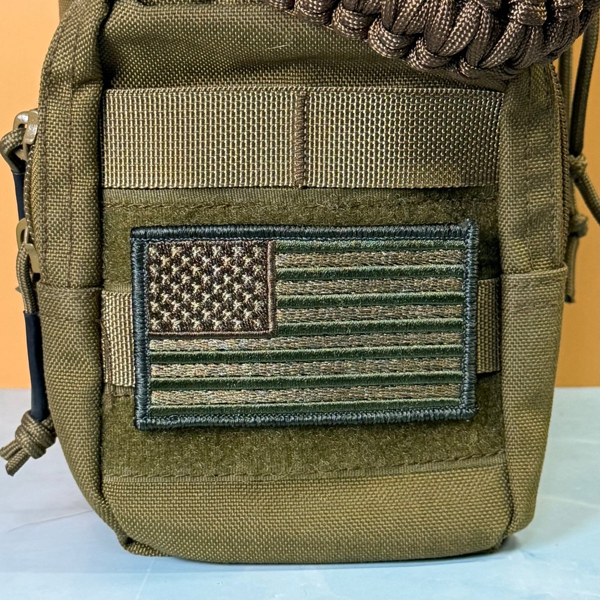Subdued FDE Tactical American Flag patch in subdued tan and green American flag, mounted on an olive backpack