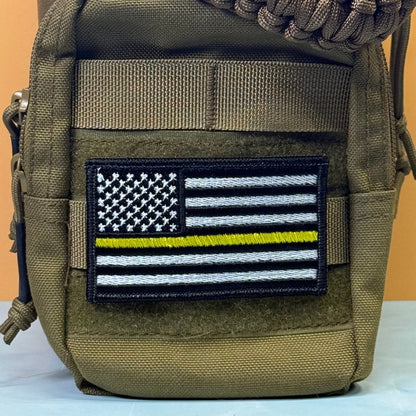 Thin Yellow Line American Flag patch in black and white American flag with one yellow stripe, mounted on an olive backpack