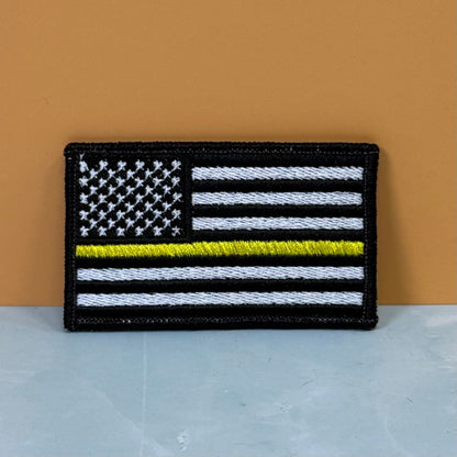 Front view of Thin Yellow Line American Flag patch in black and white American flag with one yellow stripe