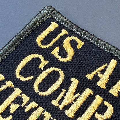 US Army Combat Veteran patch in black with tan lettering, close-up of embroidery