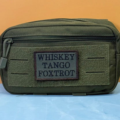 Whiskey Tango Foxtrot WTF patch in olive green with black lettering, mounted on an olive utility pouch