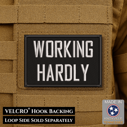 Front design and hook backing of Working Hardly patch in black with white lettering